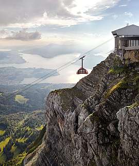 Seilbahn führt über eine beeindruckende Berglandschaft mit Blick auf den See.