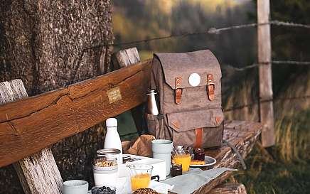 Ein rustikales Frühstück auf einer Bank in der Natur.