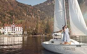 Zwei Frauen genießen den Tag auf einem Segelboot am See.