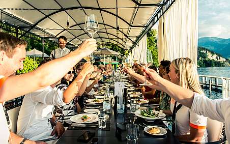 Gruppe von Menschen hebt Gläser während eines festlichen Abendessens.