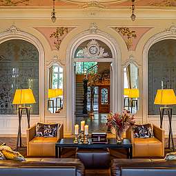 Stilvolles Wohnzimmer mit Sofas, Lampen und dekorativen Elementen.