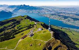 Aussicht auf grüne Hügel und einen blauen See in der Schweiz.