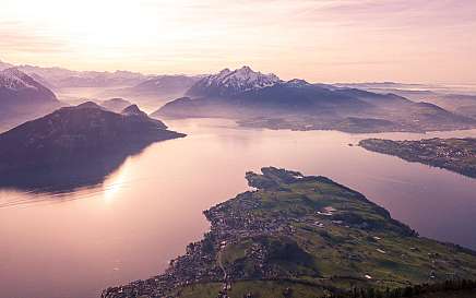 Luftaufnahme eines Sees umgeben von Bergen und Dörfern.