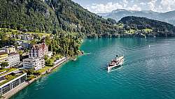 Ein historisches Gebäude mit Blick auf einen ruhigen See und Berge.