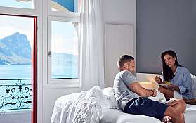 Paar genießt Frühstück im Zimmer mit Blick auf den See.