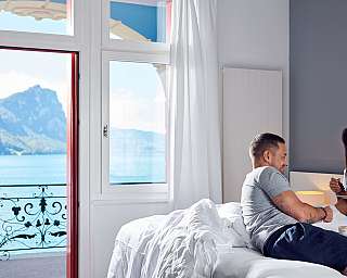 Paar genießt Frühstück im Zimmer mit Blick auf den See.