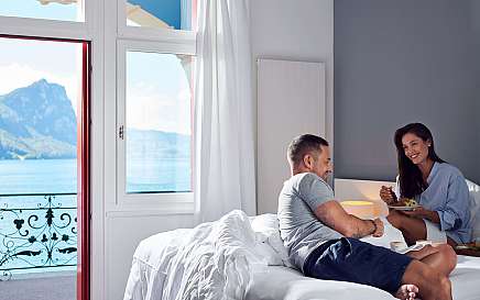 Paar genießt Frühstück im Zimmer mit Blick auf den See.