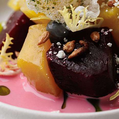 An artistically arranged plate with colourful vegetables and sauce.