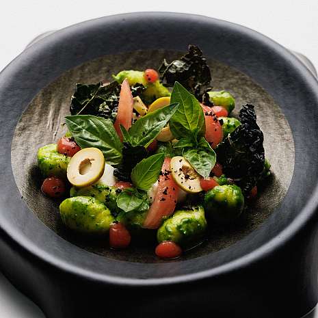 Ein kreativer Salat mit grünen Gnocchi, Tomaten und frischen Kräutern.