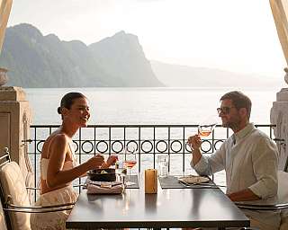 Paar genießt ein Abendessen mit Blick auf den See.