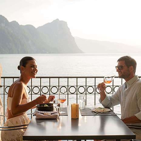 Couple enjoying a romantic dinner with a view of the lake.