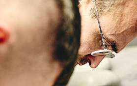 Zwei Köche arbeiten konzentriert mit frischen Kräutern in einer Schüssel.