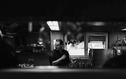 A chef is working intently in a modern kitchen.