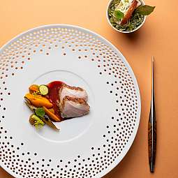 Ein kunstvoll angerichtetes Gericht mit Fleisch und Gemüse.