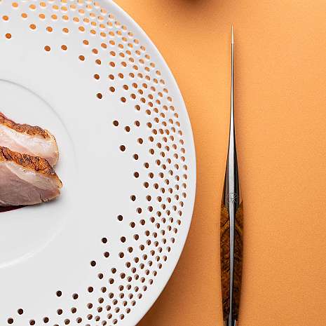 Ein Teller mit Fleischstücken und einer eleganten Gabel.