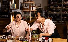 Zwei Frauen genießen ein gemeinsames Essen in einem Restaurant.