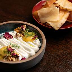 Ein Teller mit cremiger Vorspeise und knusprigen Chips.