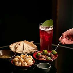 Eine Auswahl an indischen Snacks und einem Getränk auf einem Tisch.