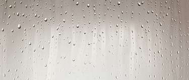 Nahaufnahme von Wassertropfen auf einer glatten Oberfläche.