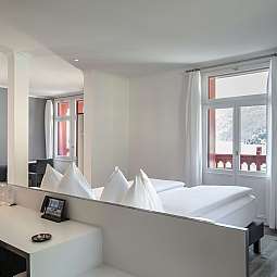 Modernes Hotelzimmer mit Doppelbett und Sitzbereich.