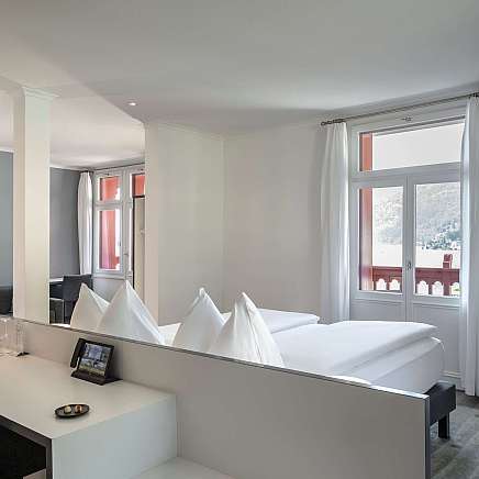 Modernes Hotelzimmer mit Doppelbett und Sitzbereich.