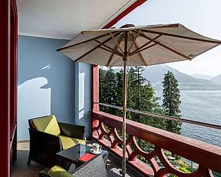 Gemütlicher Balkon mit Sitzgelegenheiten und Aussicht auf den See.