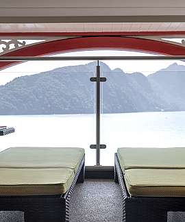 Gemütliche Liegen mit Blick auf das Wasser und die Berge.